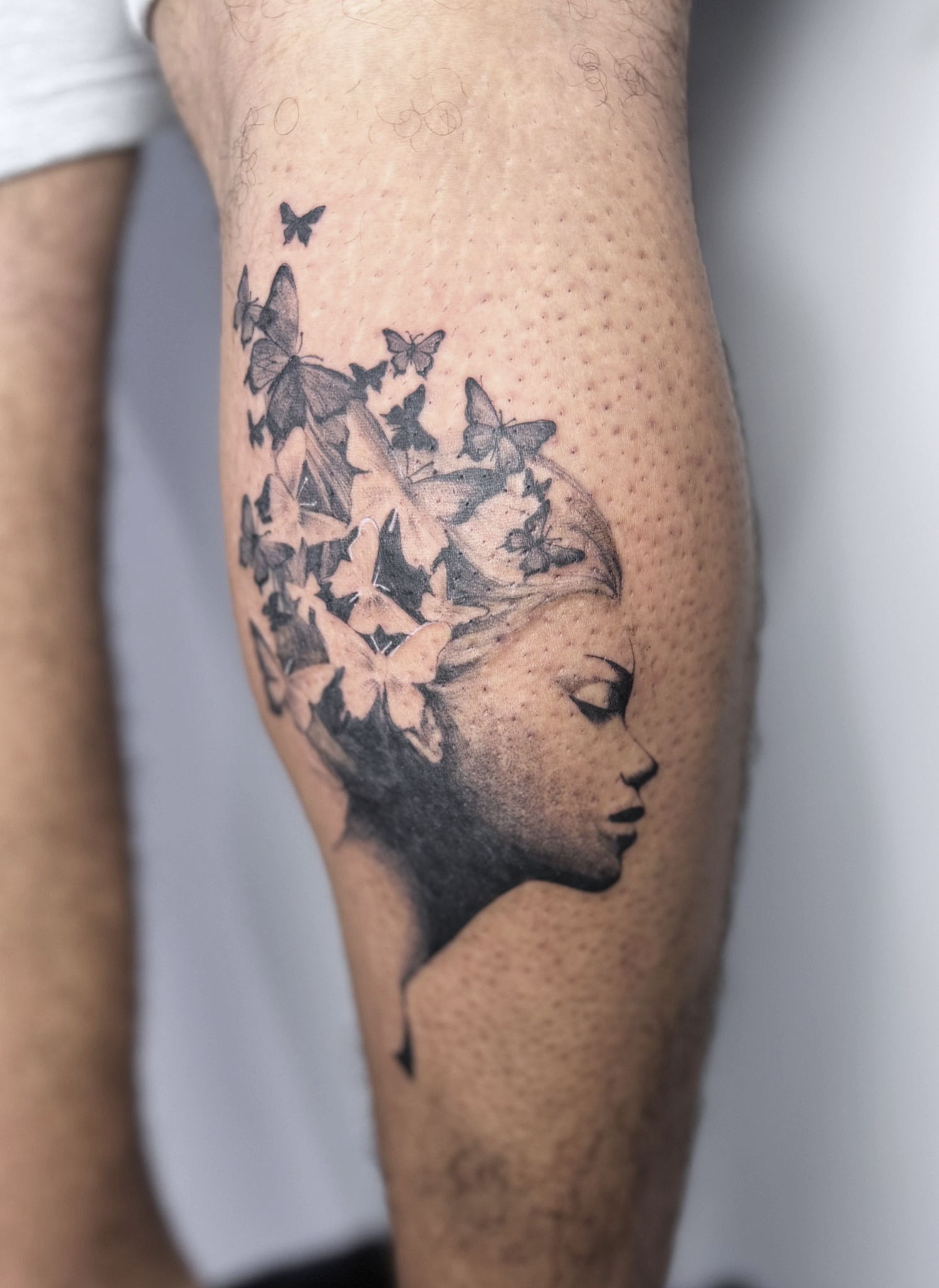 Retrato realista con flores (en negativo) y mariposas.